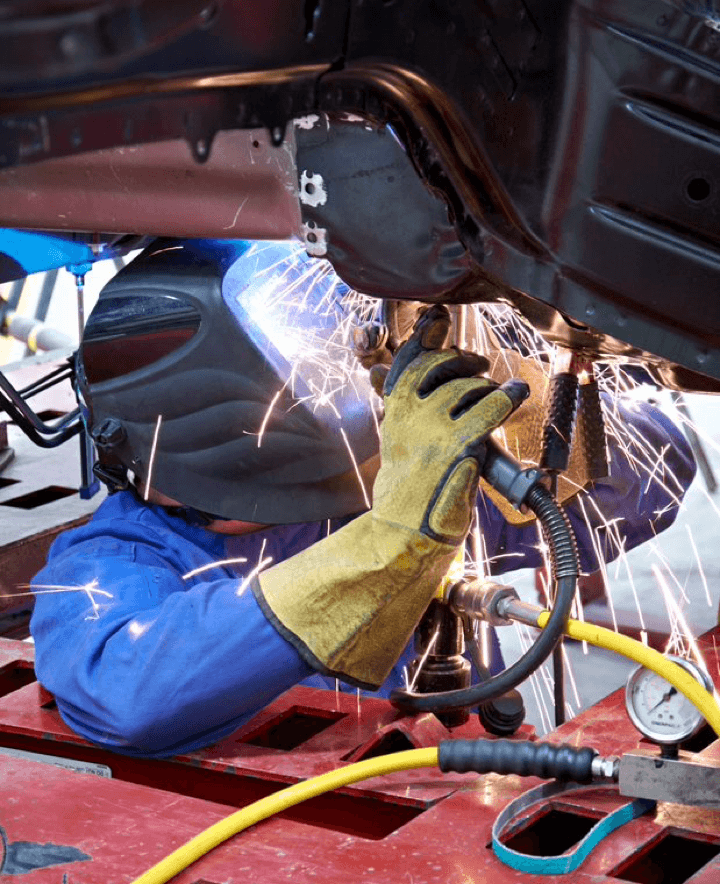 A person welding a car