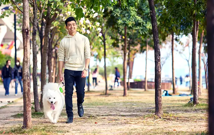 A man walks his dog, enjoying a well-earned break from work.