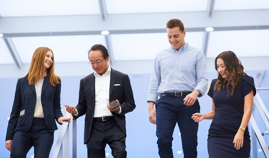 Four coworkers walking down stairs and talking
