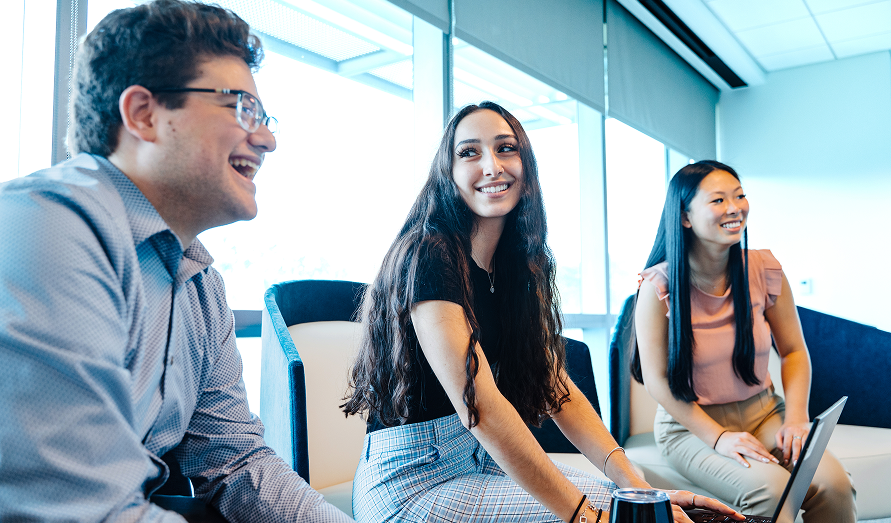 Three interns sitting together smiling