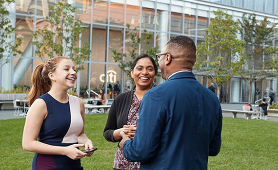 Three people conversing in a garden