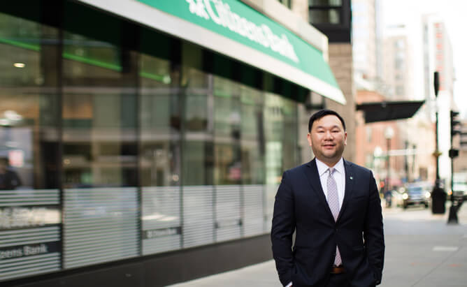Herb wearing a business suit and standing in front of the Boston Chinatown location