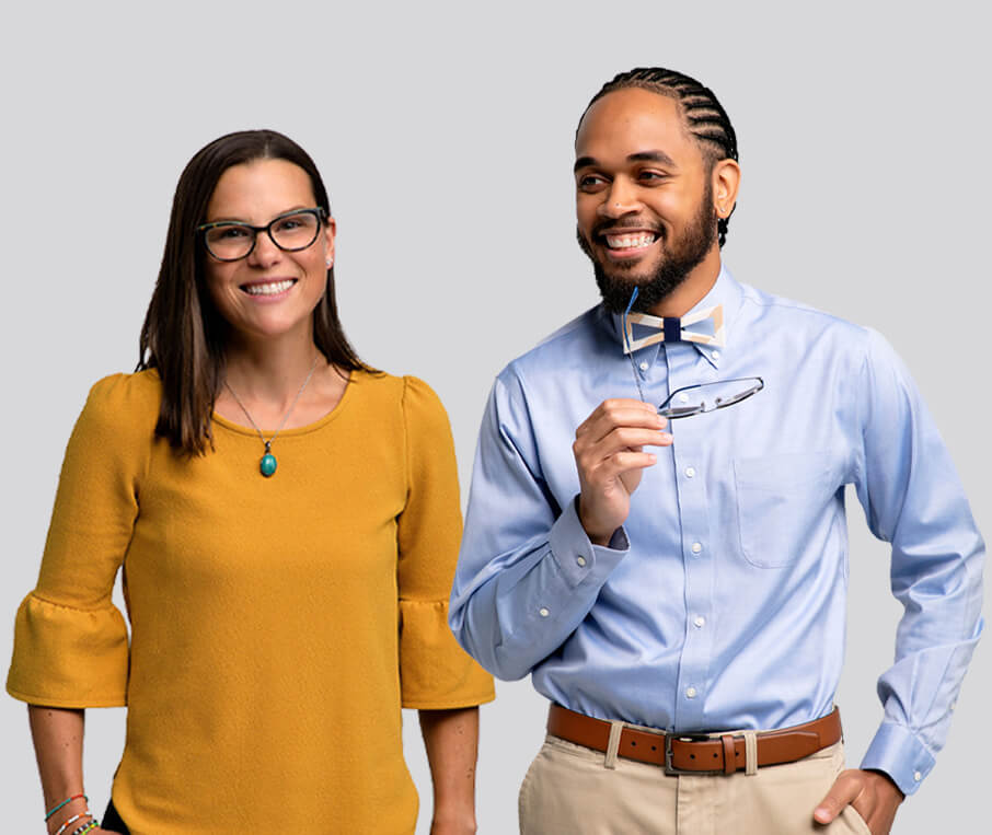 two employees wearing office attire and smiling