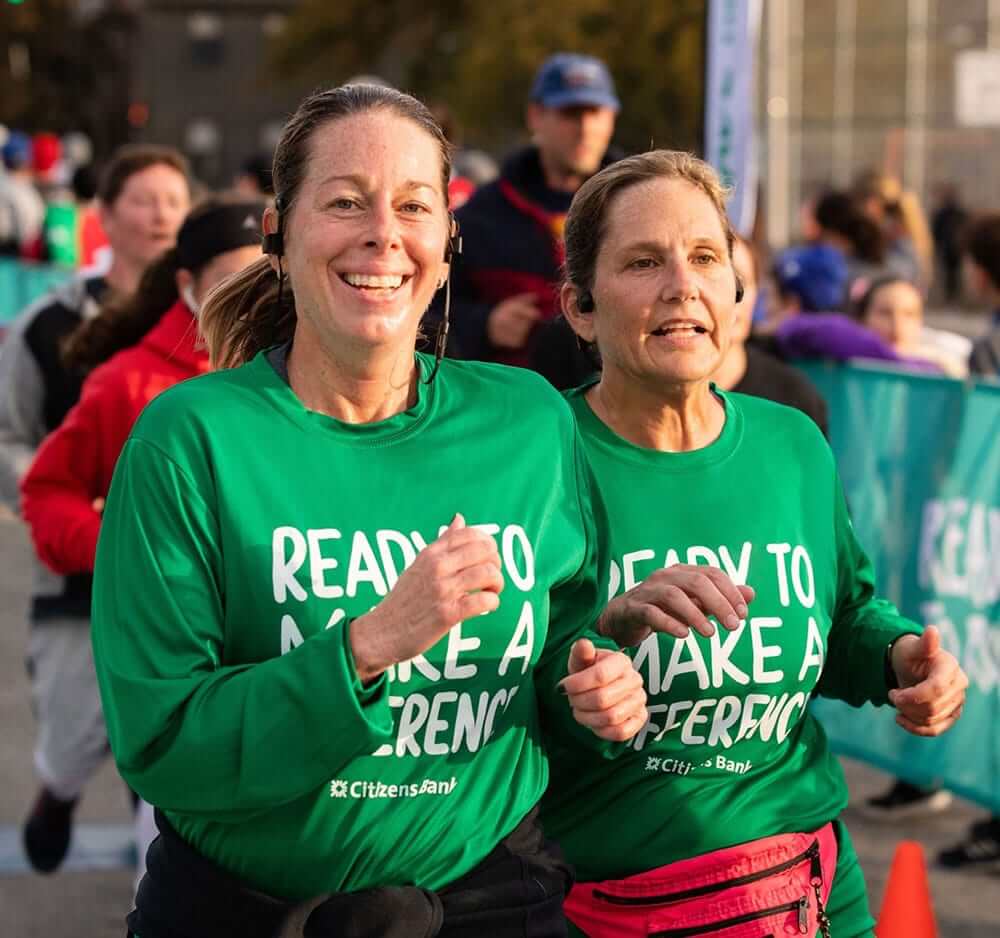 2 female employees running in a race for charity