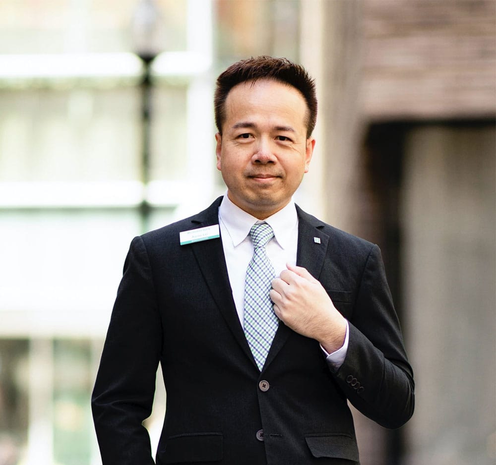 Asian male employee wearing a dark suit and a Citizens name tag