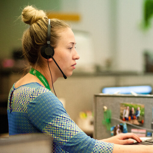 Employee talking on the telephone wearing a headset.