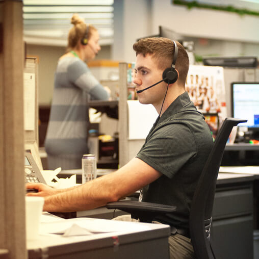 Employee talking, while wearing a telephone headset.