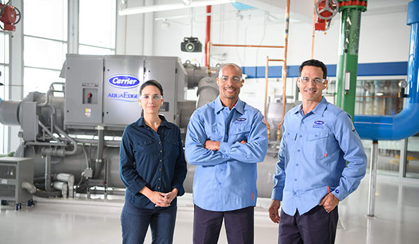 Three employees wearing protective glasses smiling for picture
