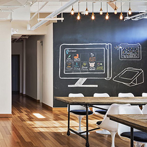 A cool=looking office with chalk drawings on a chalboard wall