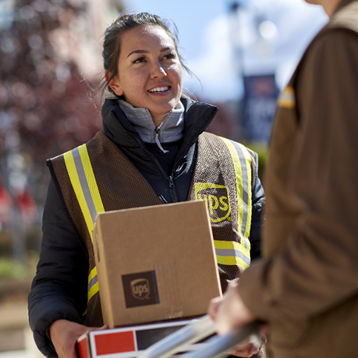 Employees delivering packages from a delivery truck.