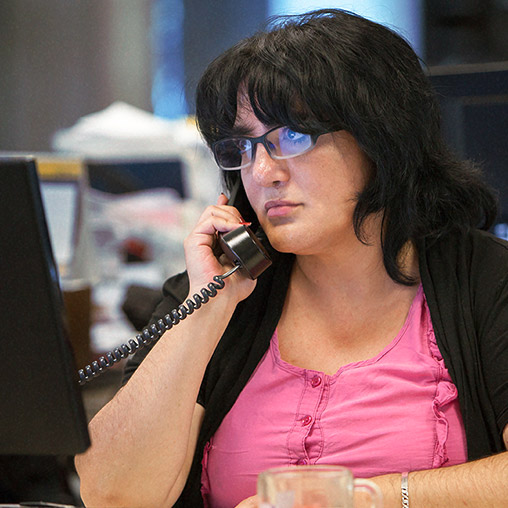 Employee smiling at the camera, while wearing a telephone headset.