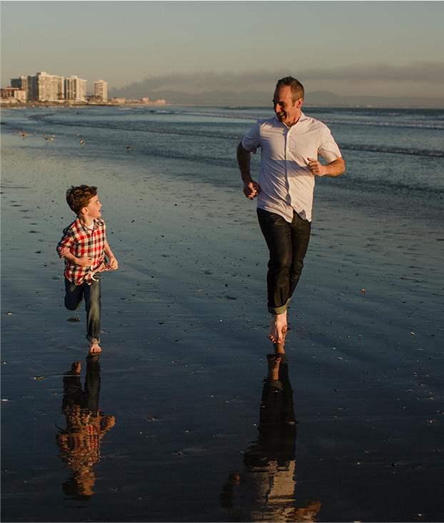 Father running on the beach with his son