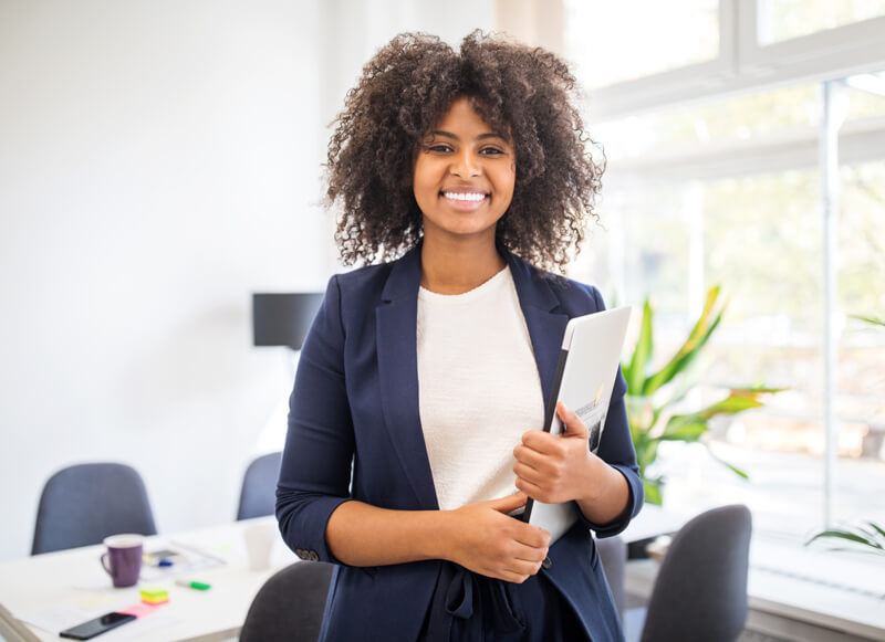 Black female BioLife employee smiling inside a sunlit office