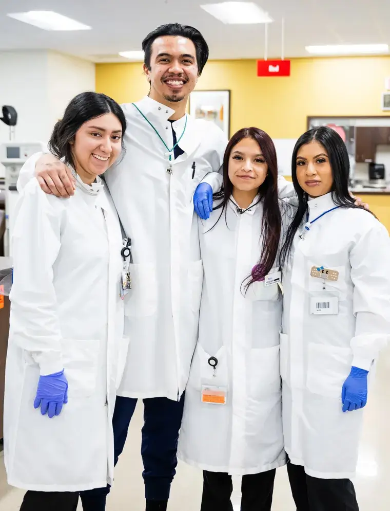 Group of four lab techs sanding together