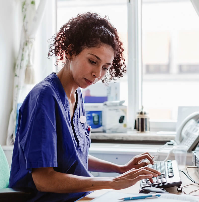 female BioLife nurse sitting at a desk and typing