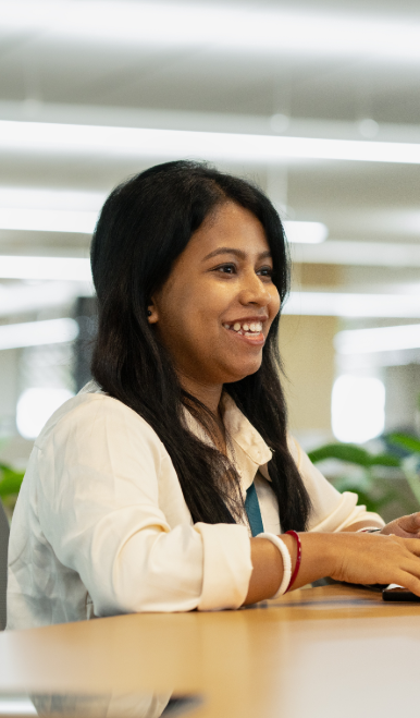 Employee smiling during a team meeting in the office