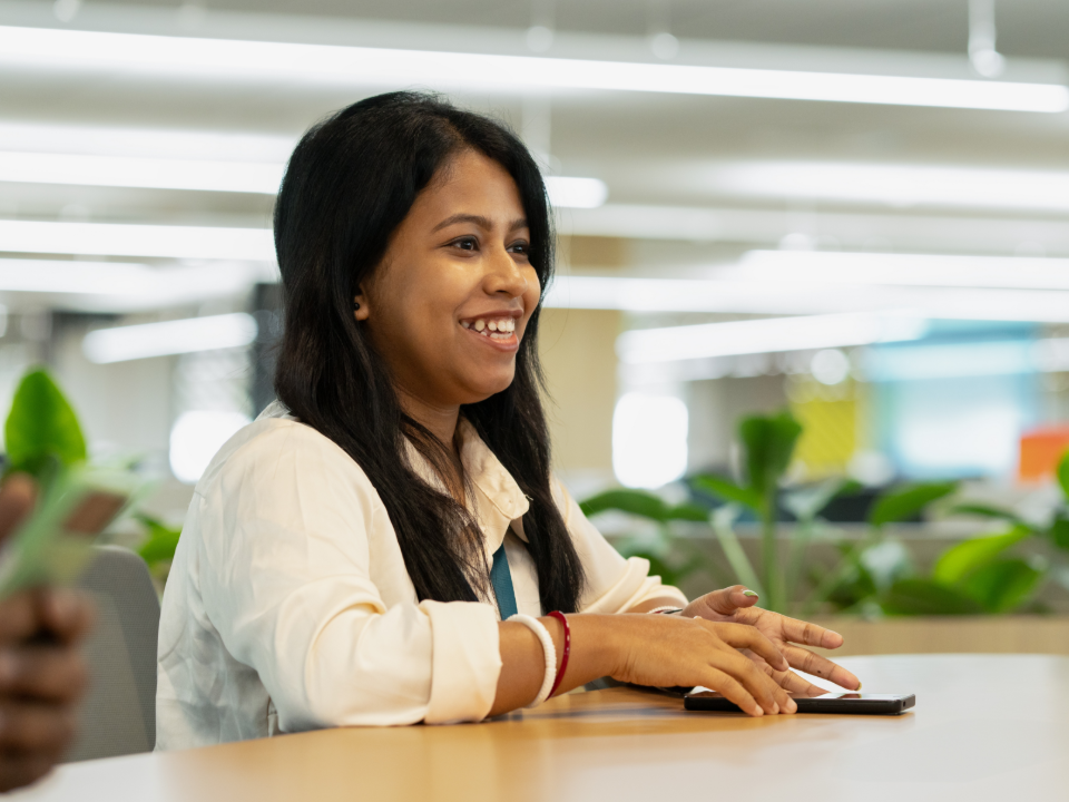 Employee smiling during a team meeting in the office