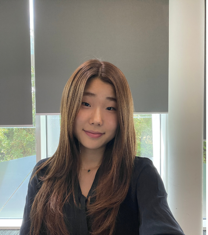 Hyo, an Arm engineering intern, smiling at the camera in an office