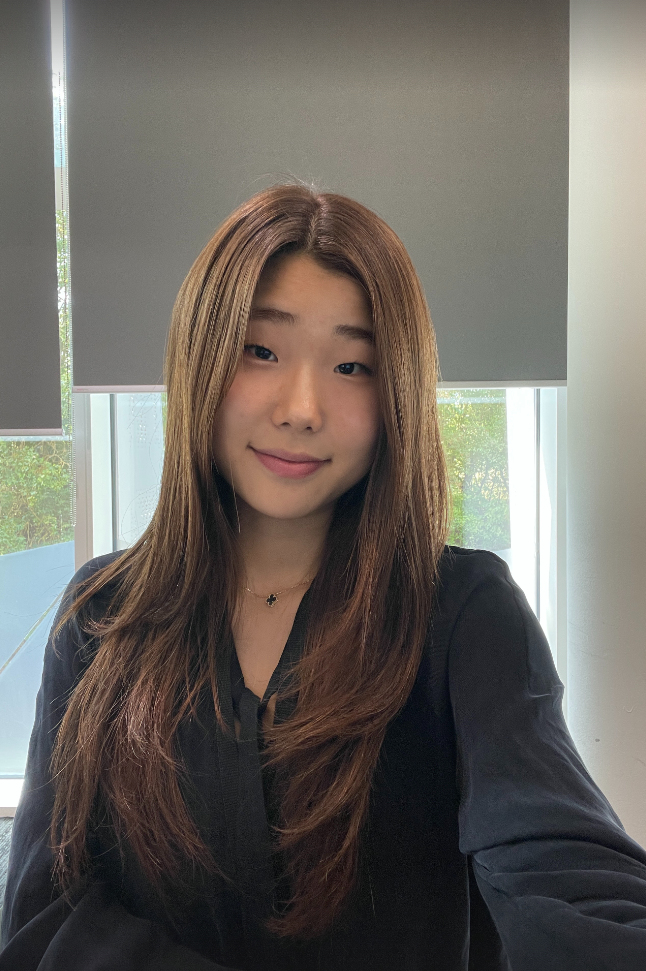 Hyo, an Arm engineering intern, smiling at the camera in an office