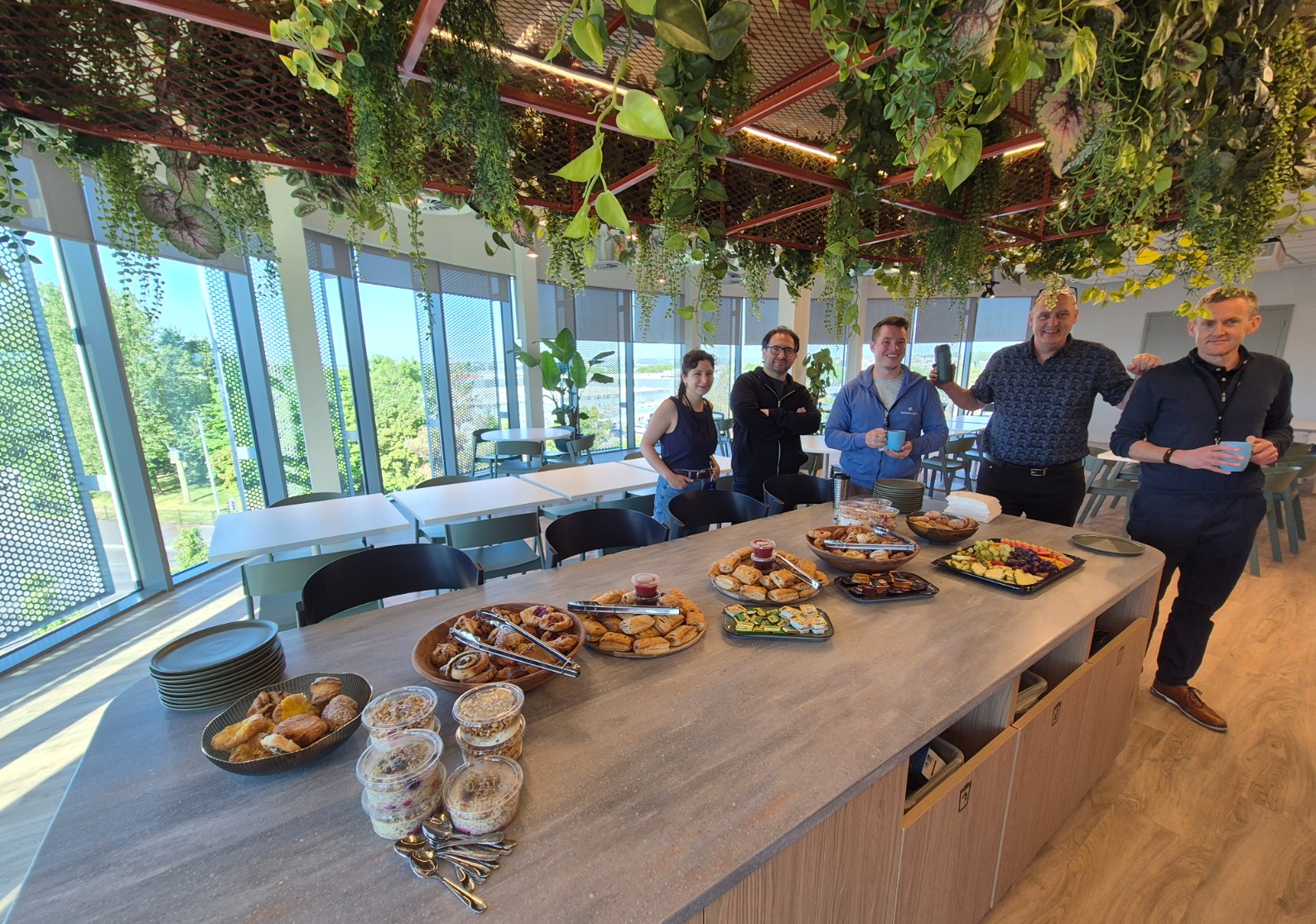 Man speaking to seated audience in office event.