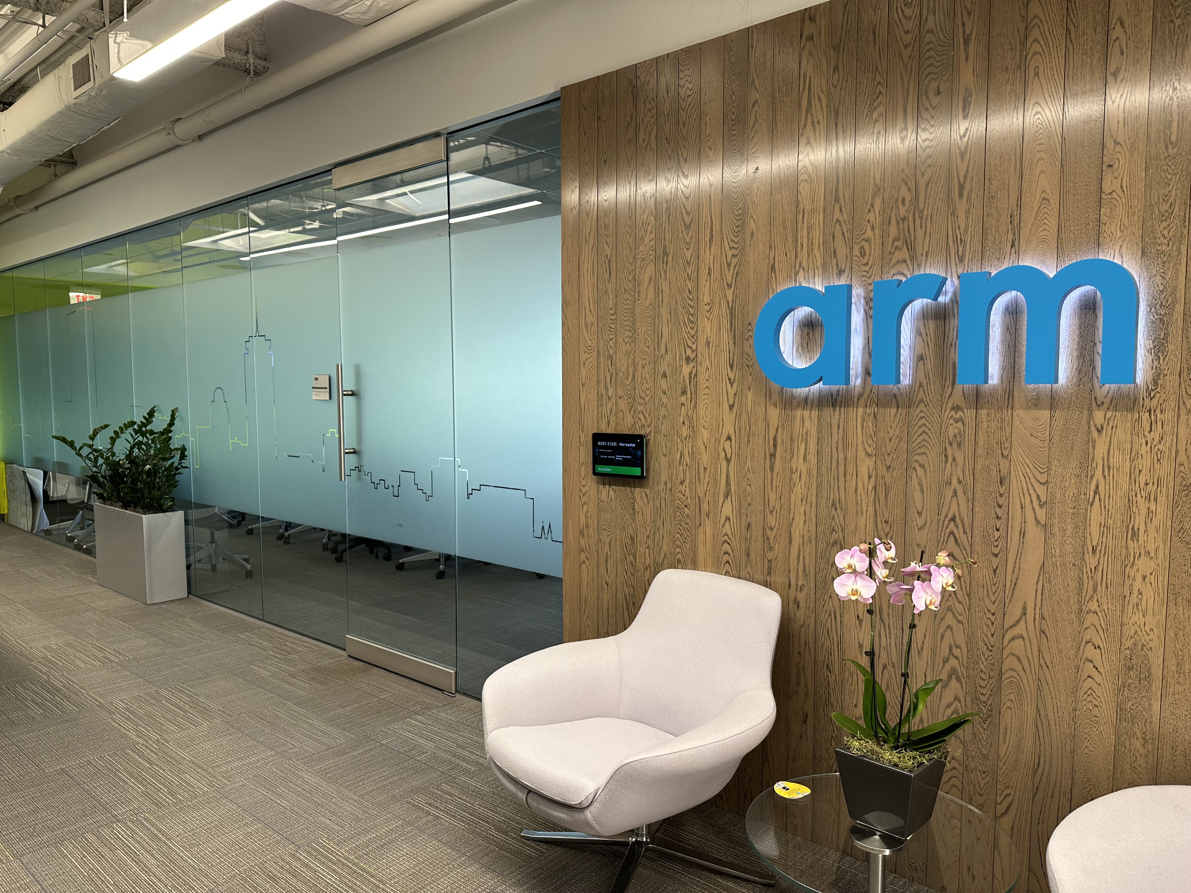 Modern office lobby with "arm" branding on a wooden wall