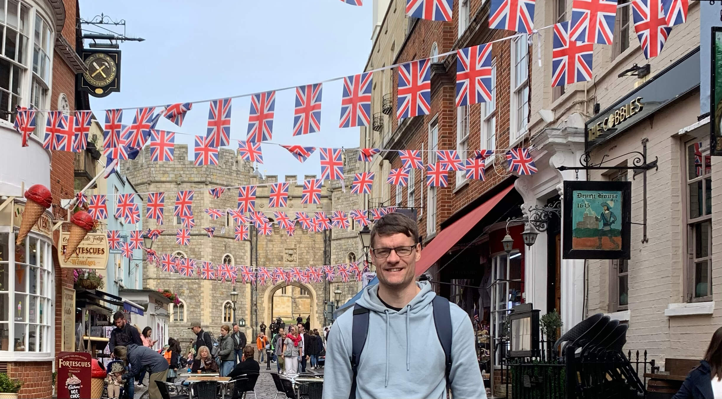 Man in hoodie under Union Jack bunting.