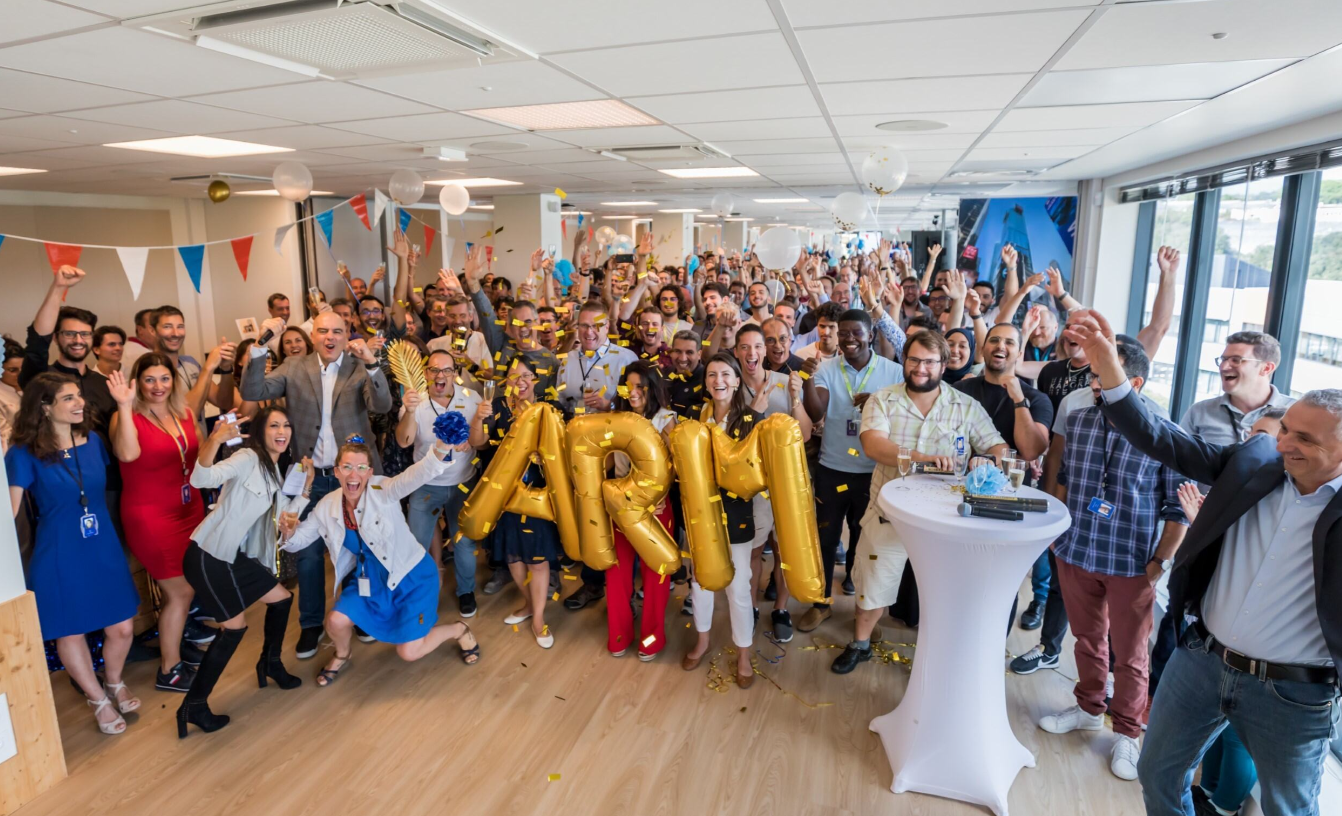 Large group celebrating with "ARM" balloons.