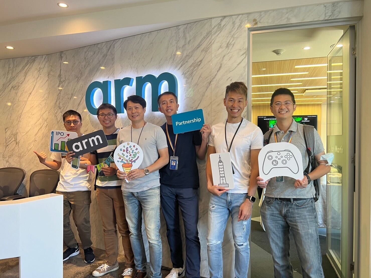 Six people holding signs at Arm office.