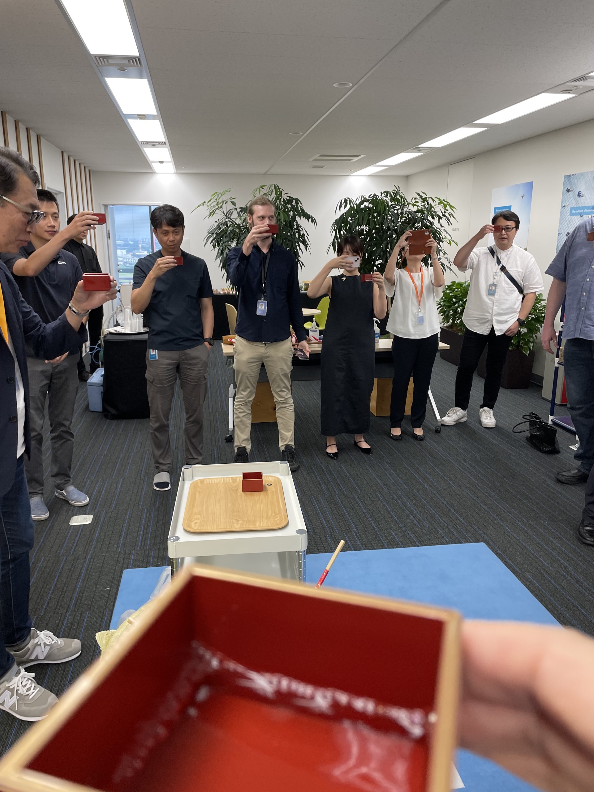 Group toasting with red masu cups