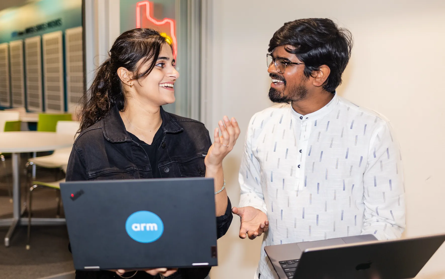 Two people collaborating with laptops.