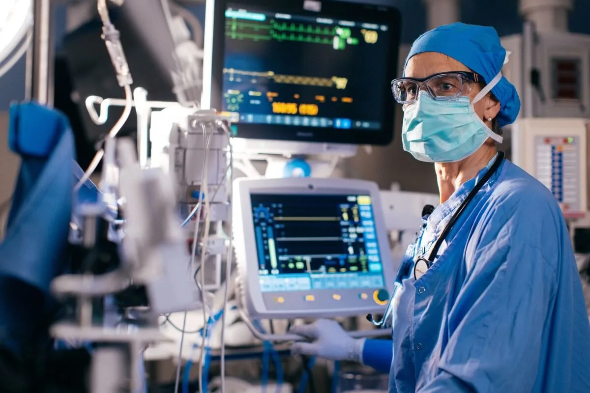 An anesthetist is focused while working in a medical setting.