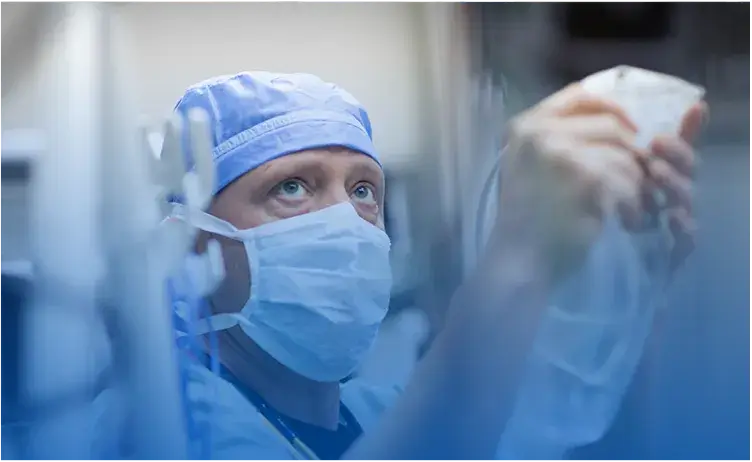 An anesthetist is focused while working in a medical setting.