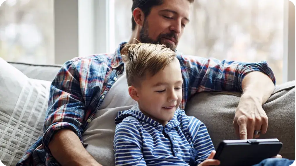 father and son looking at a tablet