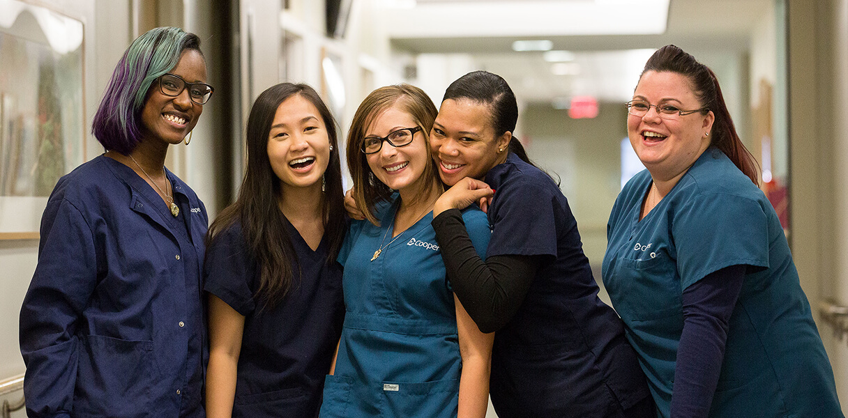 Group of Nurses stating in front of a nurses station