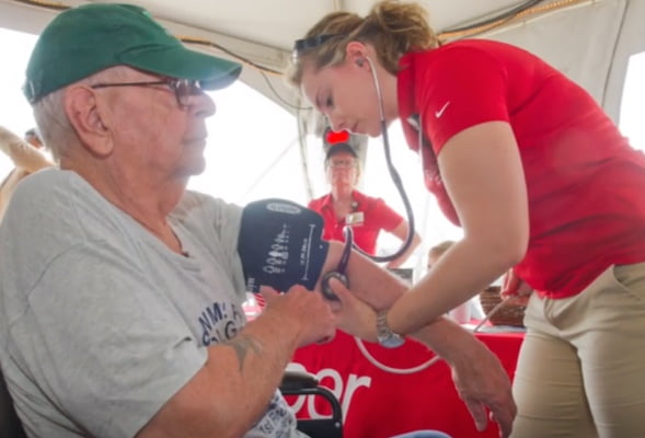 Older male getting blood pressure tested by female employee