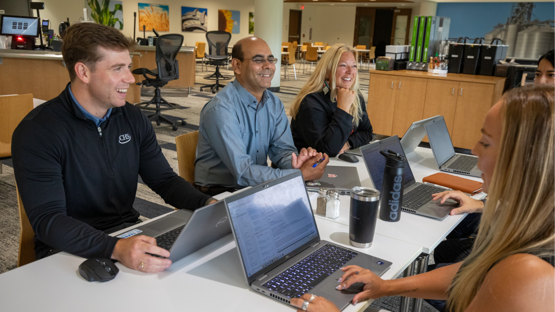 Group of employees talking around a table.