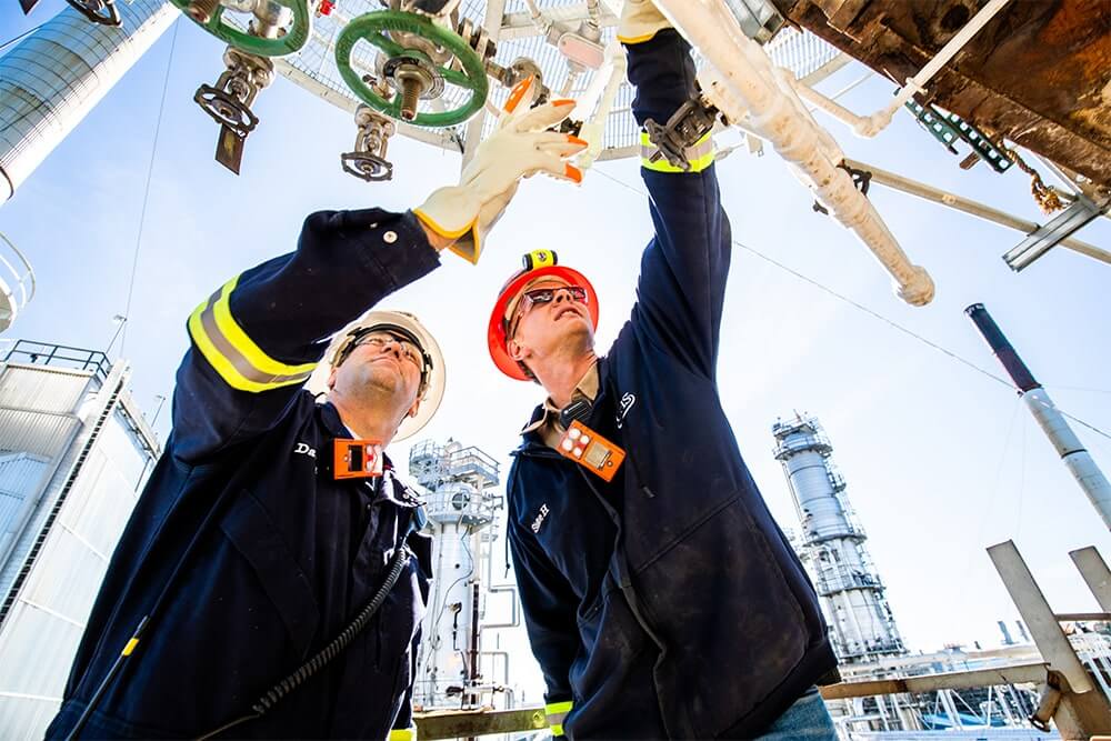 Two employees looking at a valve