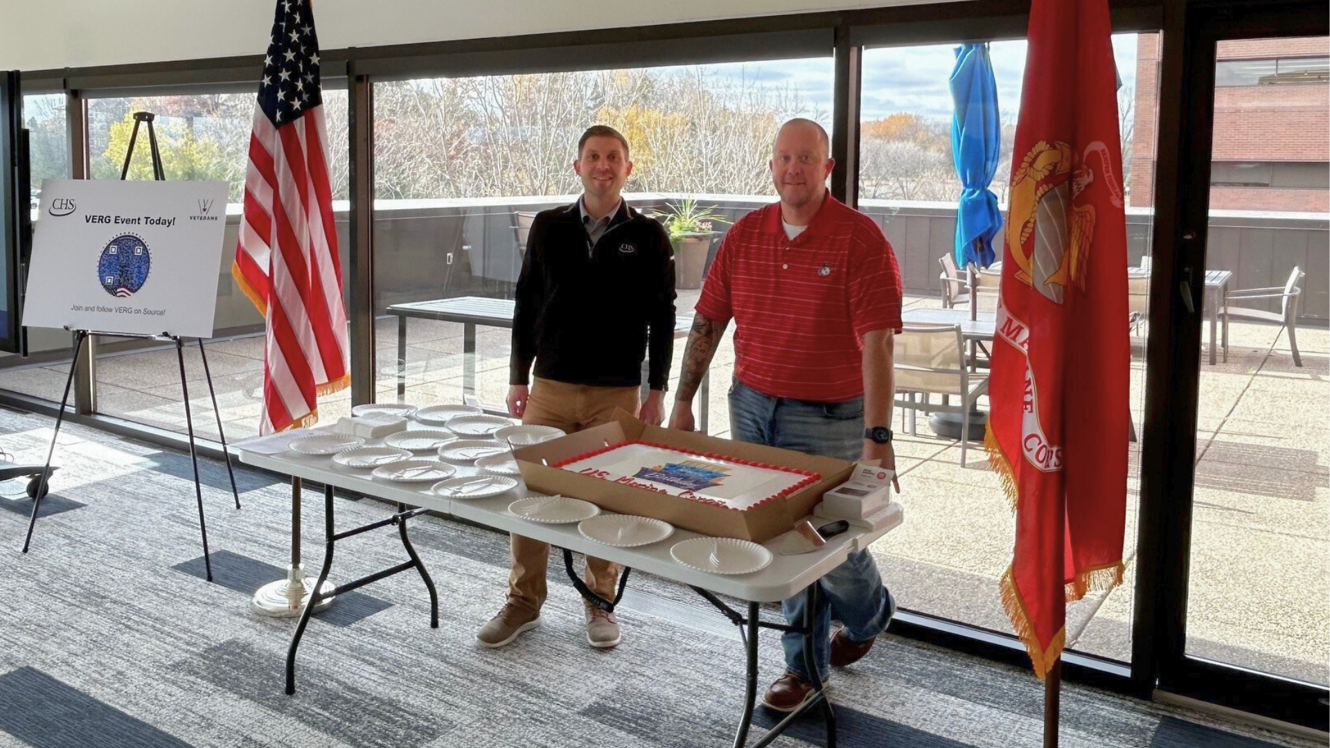 Two employees standing at a table serving cake.