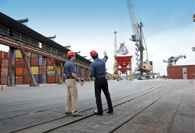 Dois homens observando um guindaste.