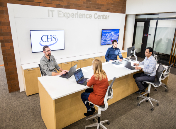 Four employees sitting at a large desk