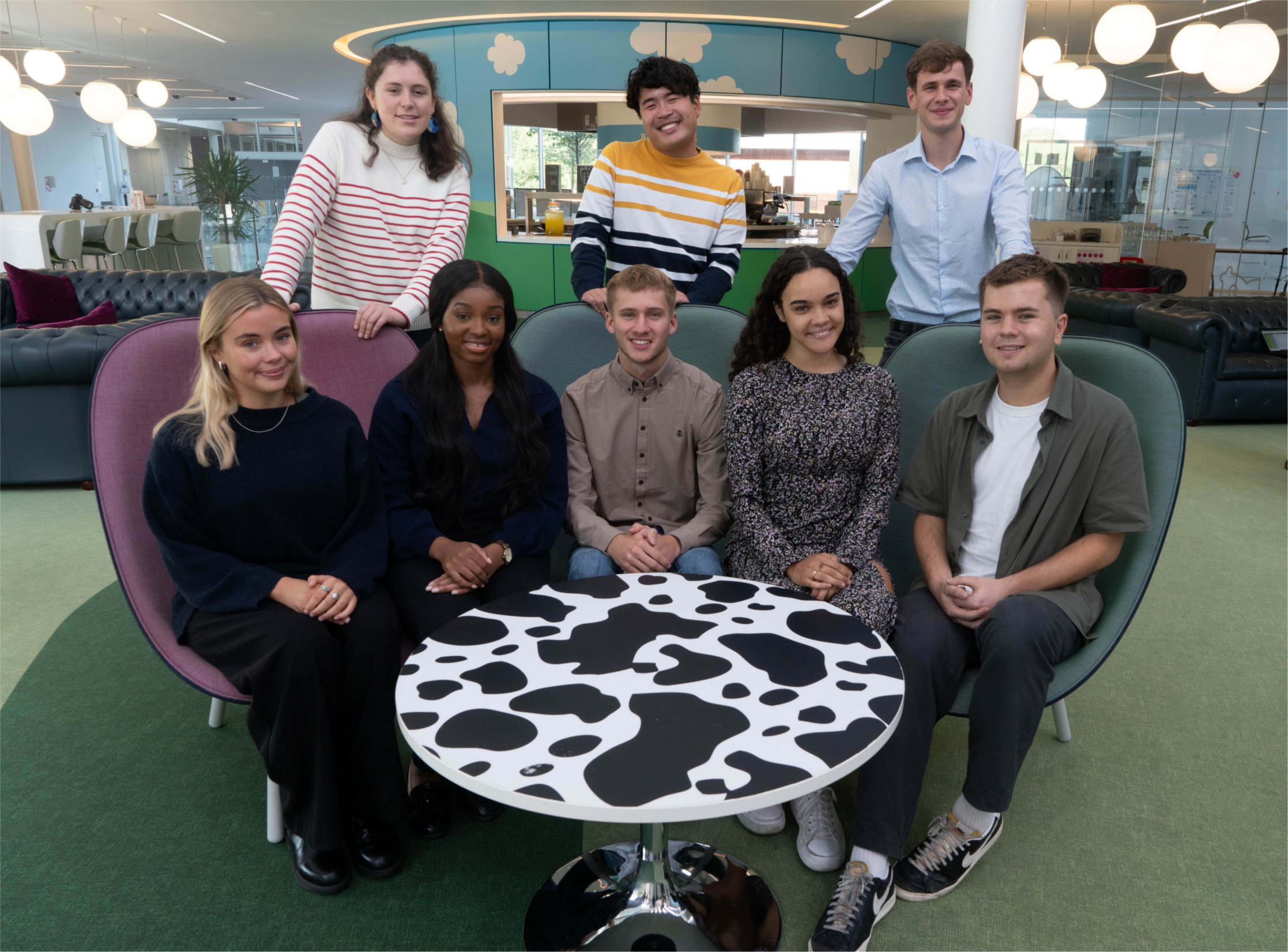 A group of young people smiling in an office