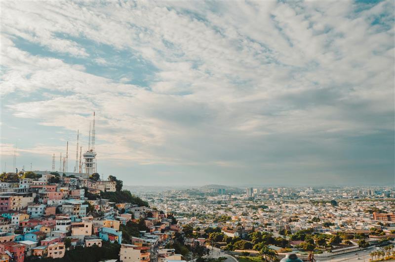 Colorful hillside houses overlooking a cityscape.