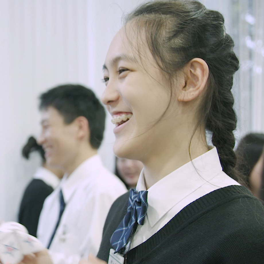 Two people in conversation at a table in a modern office environment.