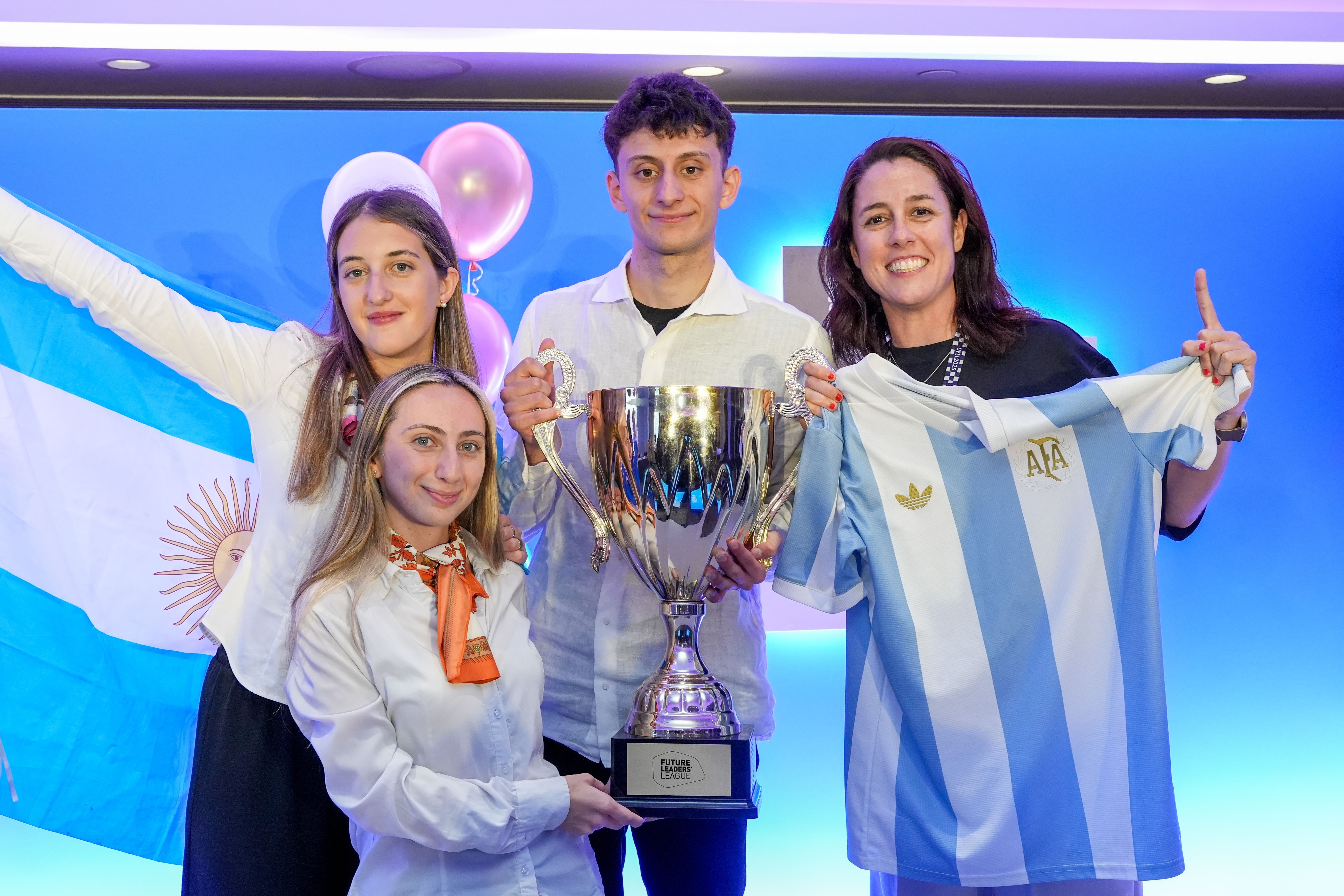 Group holding trophy and Argentine flag indoors