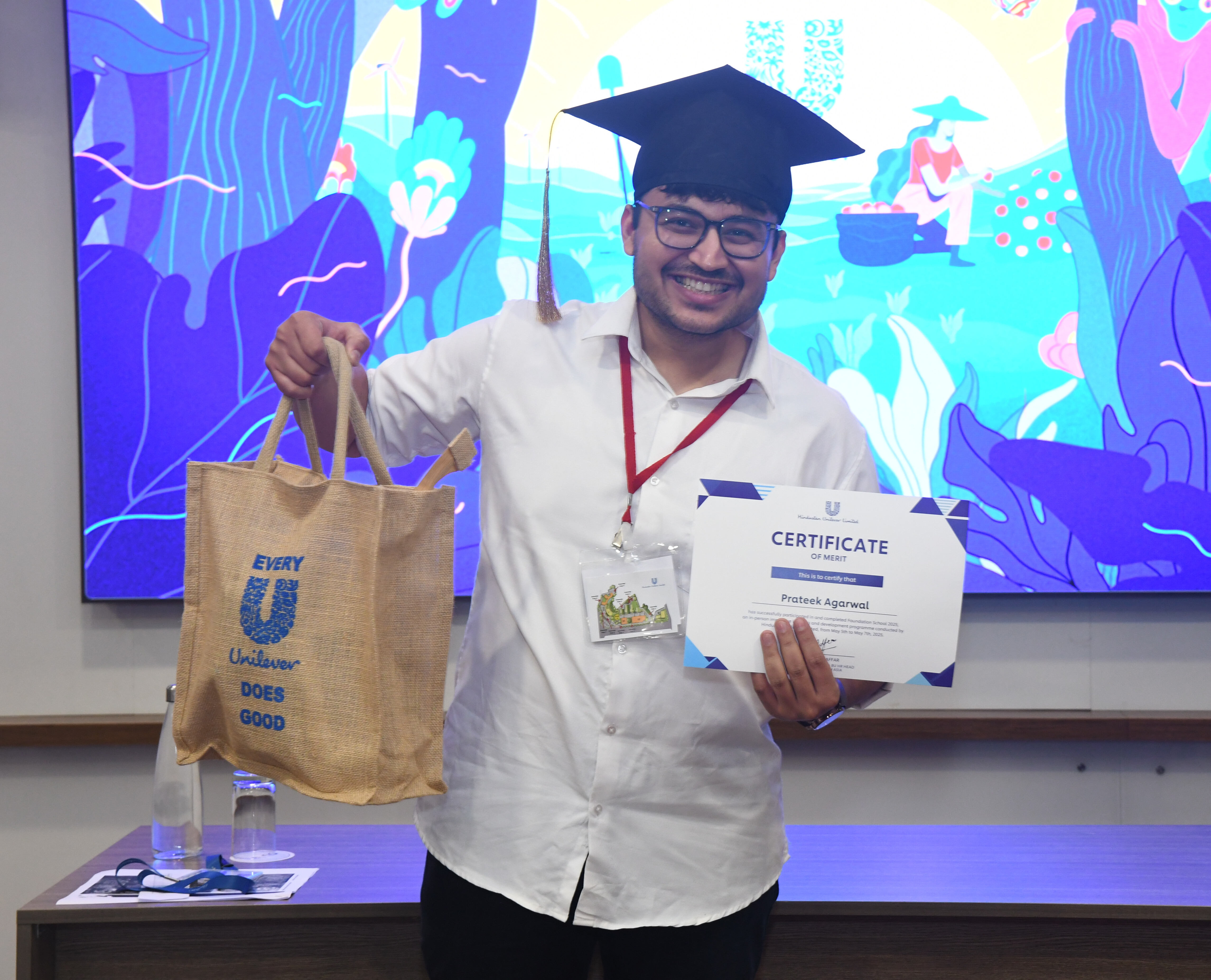 Two people in conversation at a table in a modern office environment.