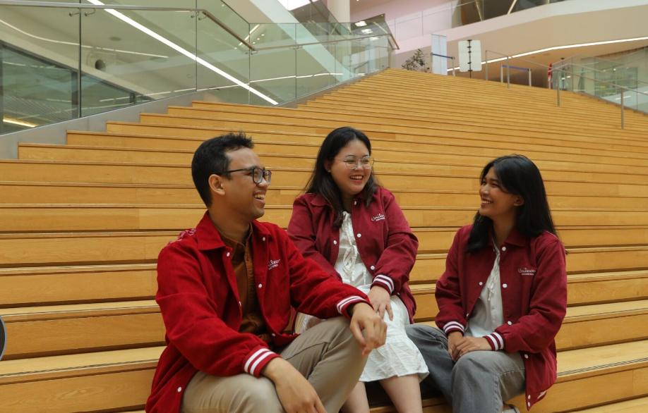 Two people in conversation at a table in a modern office environment.