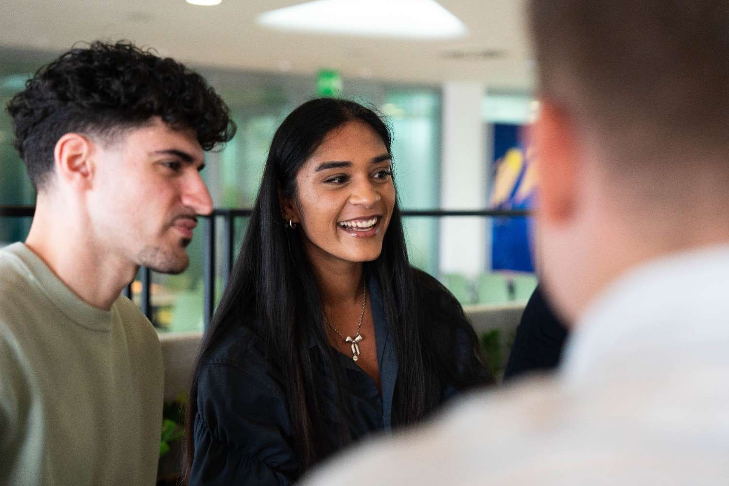 People smiling and talking together in an office
