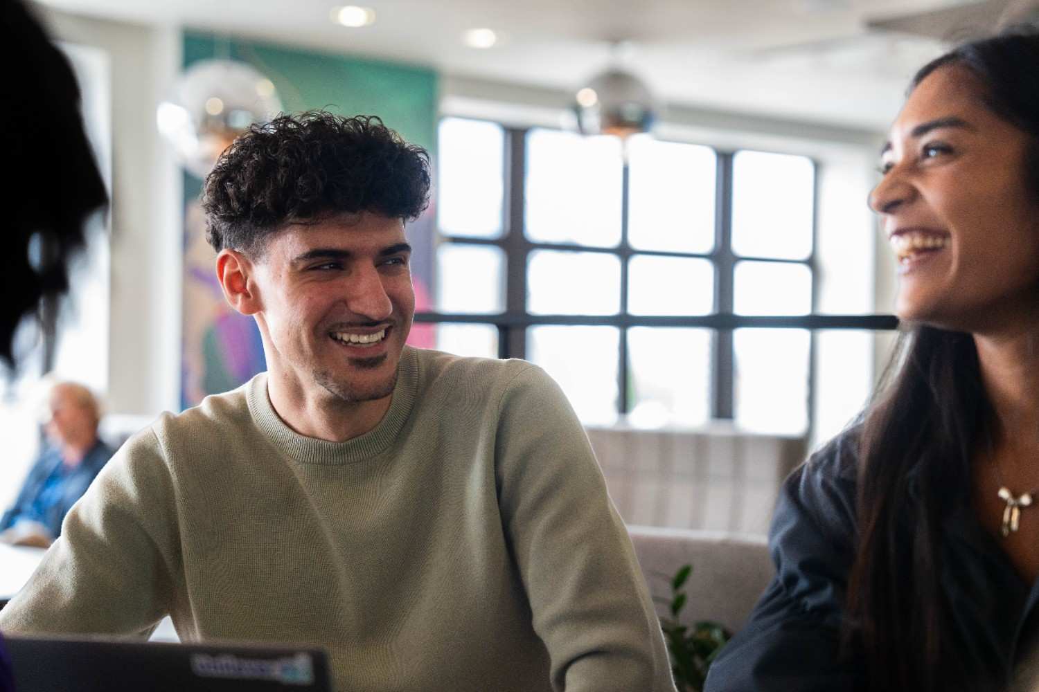 Two colleagues smiling and talking in a bright office
