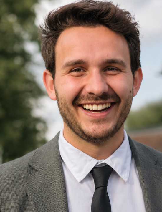 Matthew, Global Brand Manager for AXE at Unilever, smiling outdoors in a suit