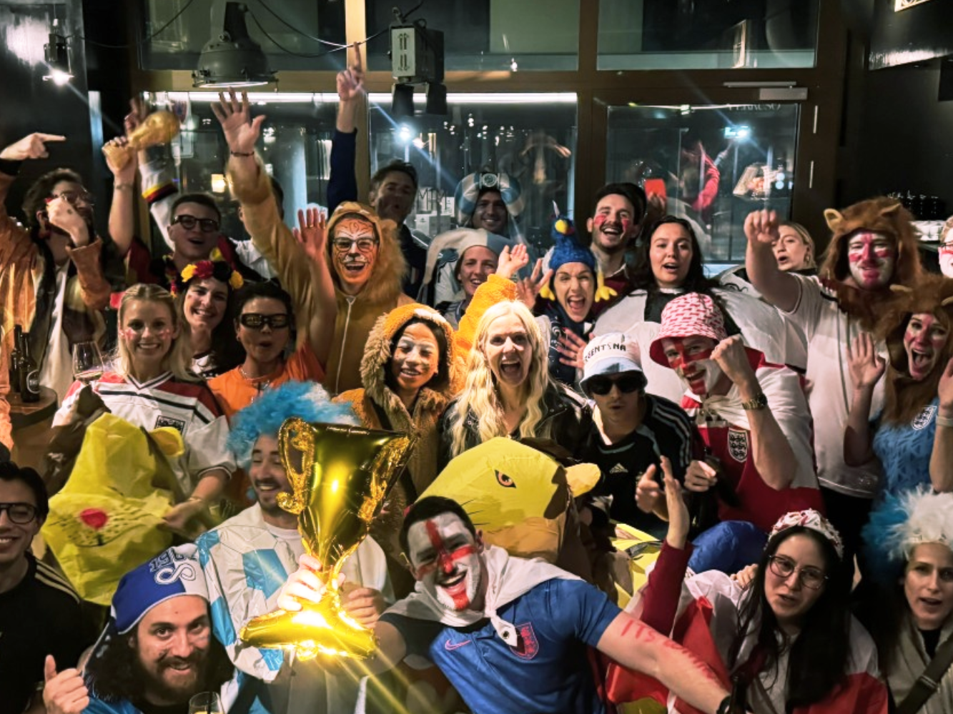 A large Unilever team in football shirts and costumes celebrating together at a World Cup themed social event.